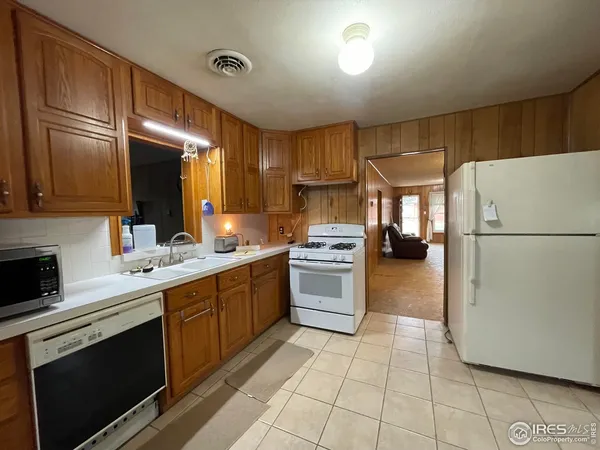 a kitchen with a sink a refrigerator and a stove top oven