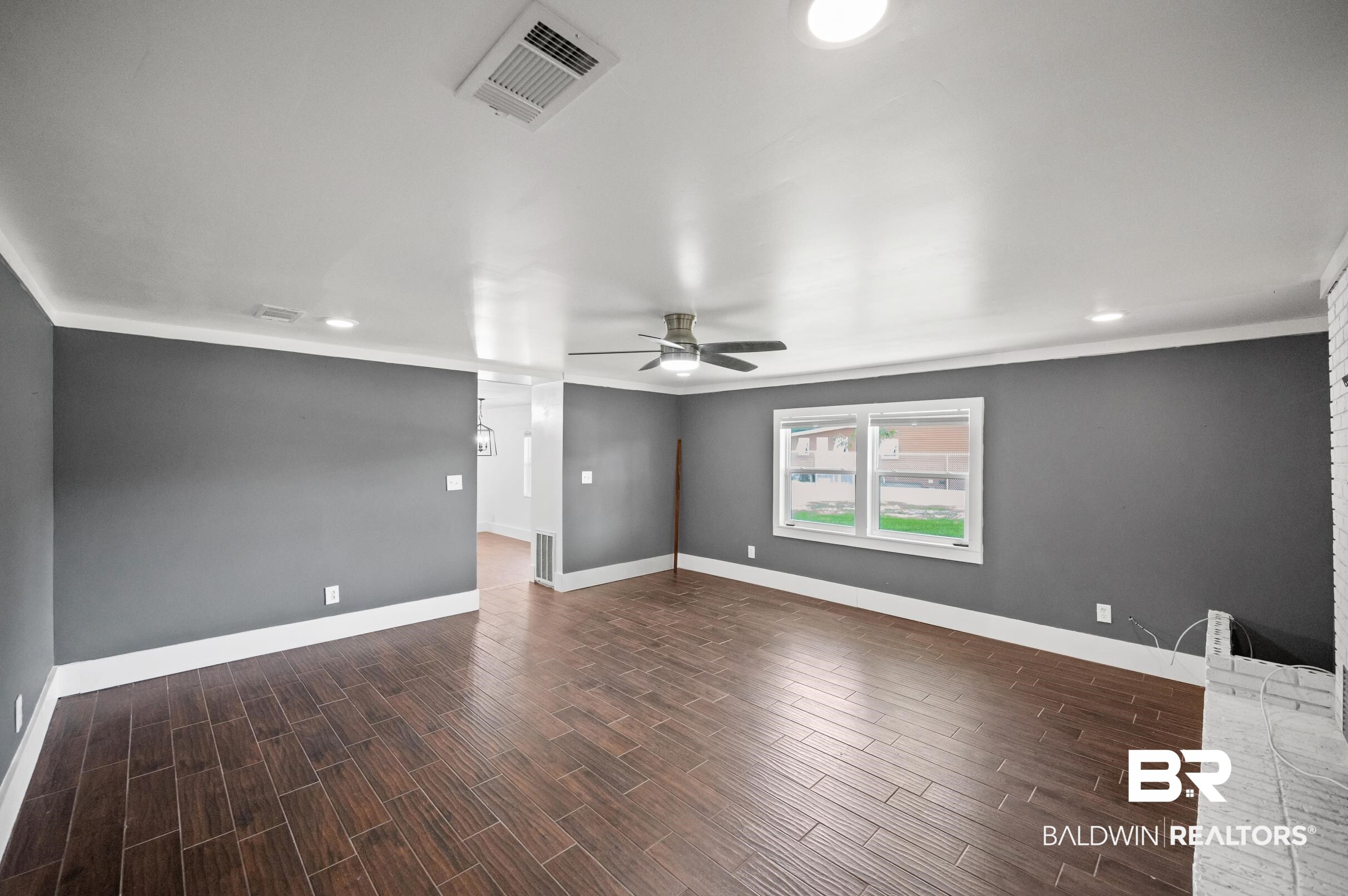 24663 Chestnut Street Elberta, AL 36530 - Photo 15 of 22 Spacious living area featuring wood-finish flooring, a white brick fireplace, and modern recessed lighting