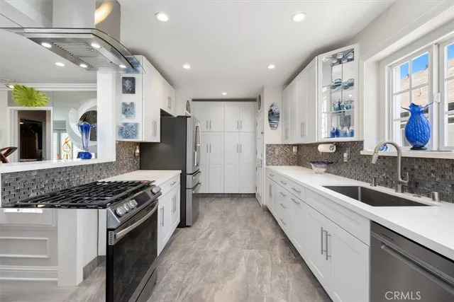 a kitchen with counter top space a sink appliances and a window