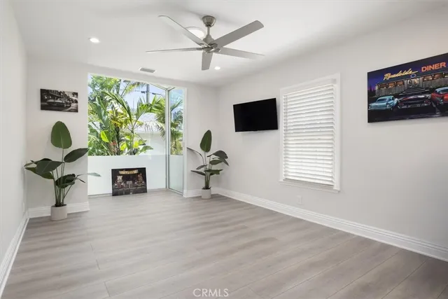 a view of an empty room with window and wooden floor