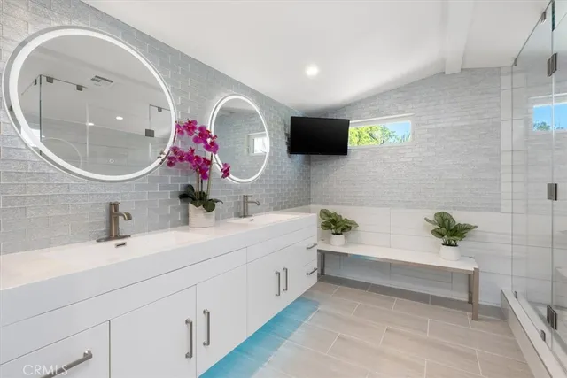 a bathroom with a double vanity sink mirror and bathtub