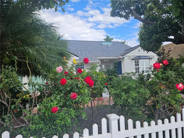 a front view of a house with a yard and potted plants