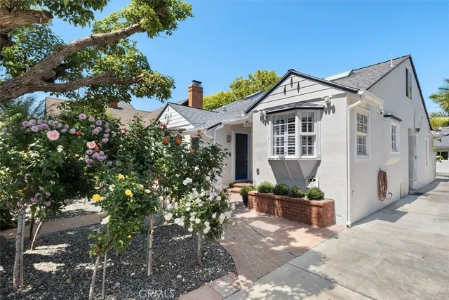a front view of a house with a yard and potted plants