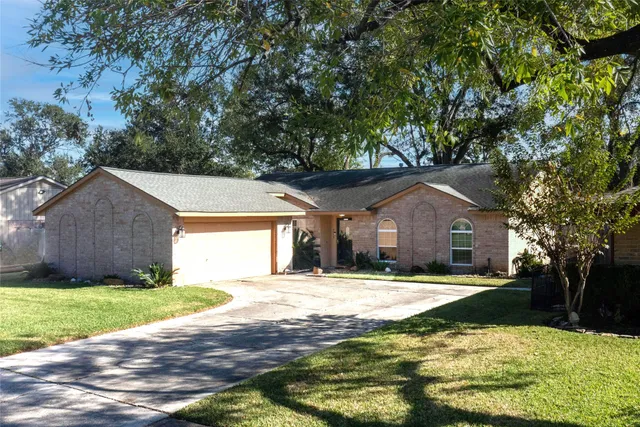 a front view of a house with yard and trees