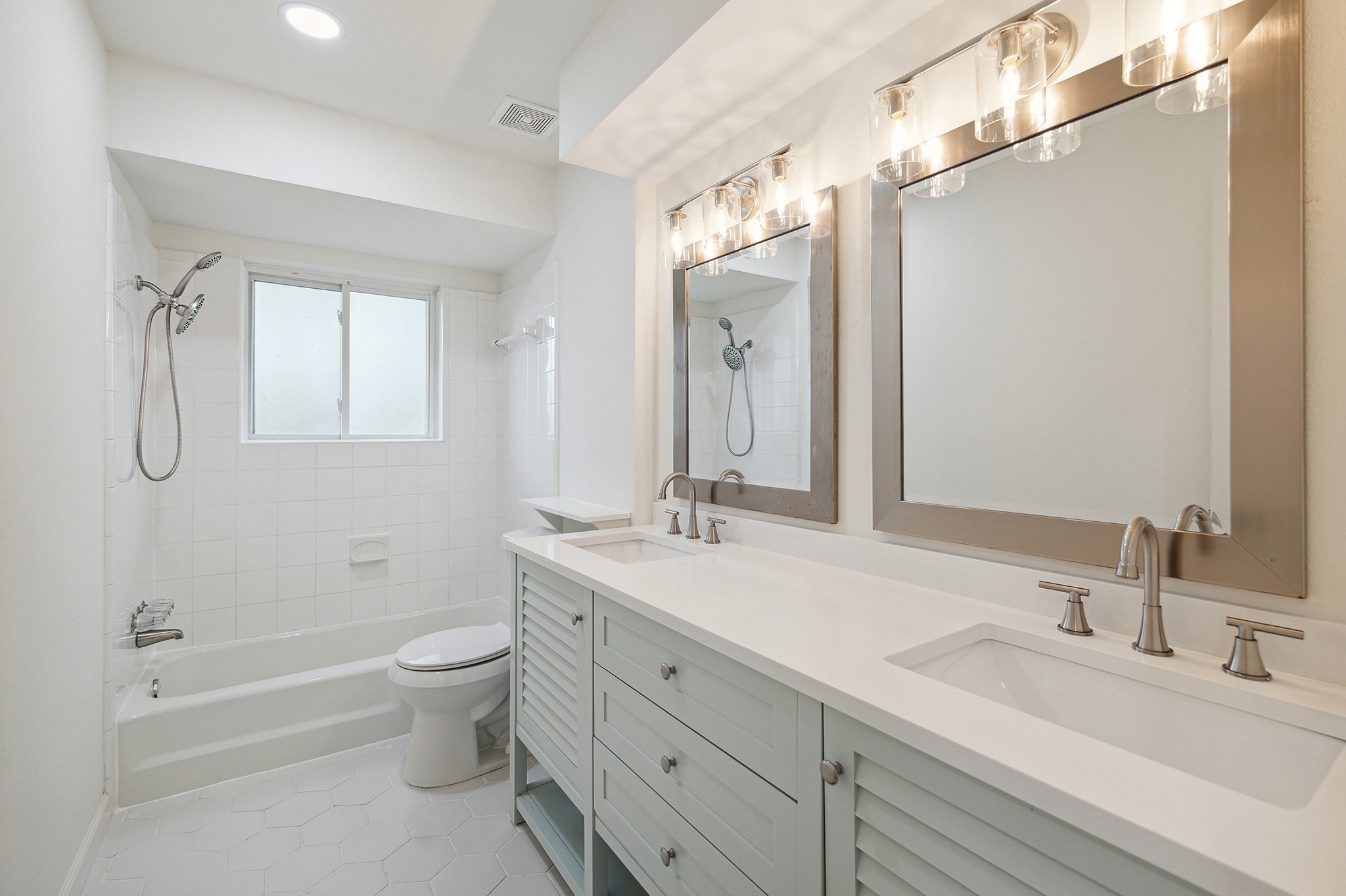 9719 Springmont Drive Houston, TX 77080 - Photo 28 of 32 Hallway bathroom is such a beauty! Elegant vanity console in a soothing celadon color really elevates the space! As does DOUBLE SINKS so no one is fighting over sink usage! GLEAMING plumbing fixtures, mirrors, and wall sconces grace this completely redone bath!!