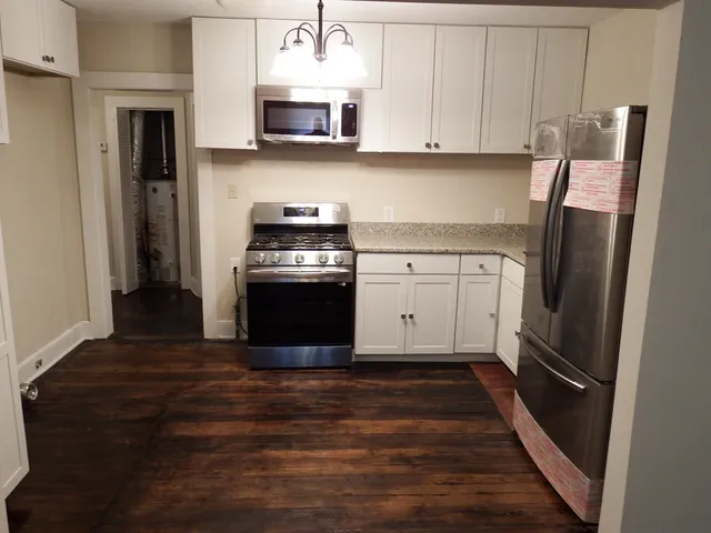 a kitchen with stainless steel appliances granite countertop a refrigerator and a stove top oven