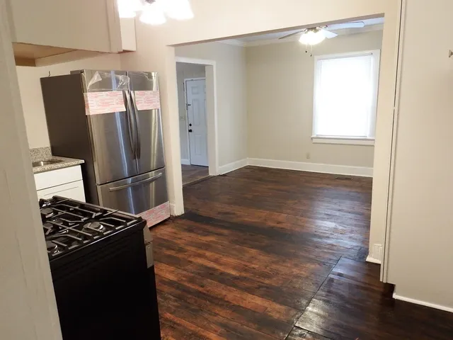 a kitchen with wooden floor and a refrigerator