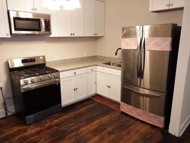 a kitchen with stainless steel appliances and wooden floor