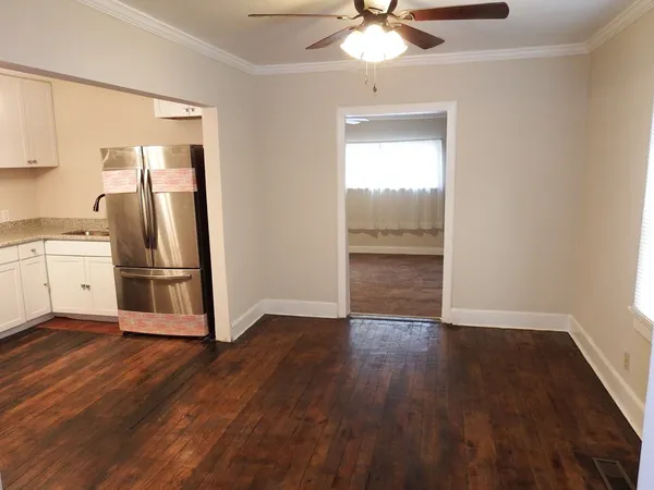 a view of a kitchen with a fridge wooden floor and a window