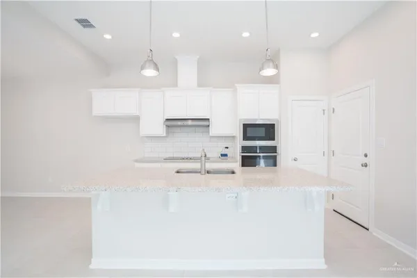 a kitchen with stainless steel appliances white cabinets and a refrigerator