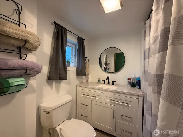 a bathroom with a toilet sink and mirror