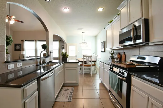 a kitchen with stainless steel appliances a sink stove and cabinets