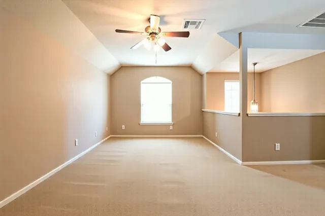 an empty room with a window and a ceiling fan