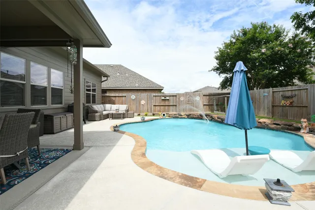 a swimming pool with outdoor seating and yard