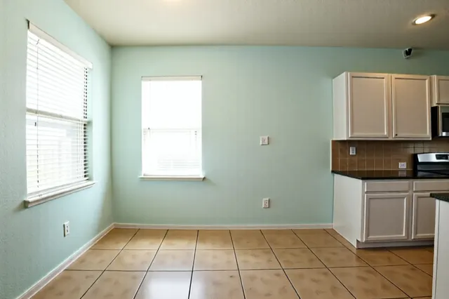 view of kitchen with granite countertop cabinets and window