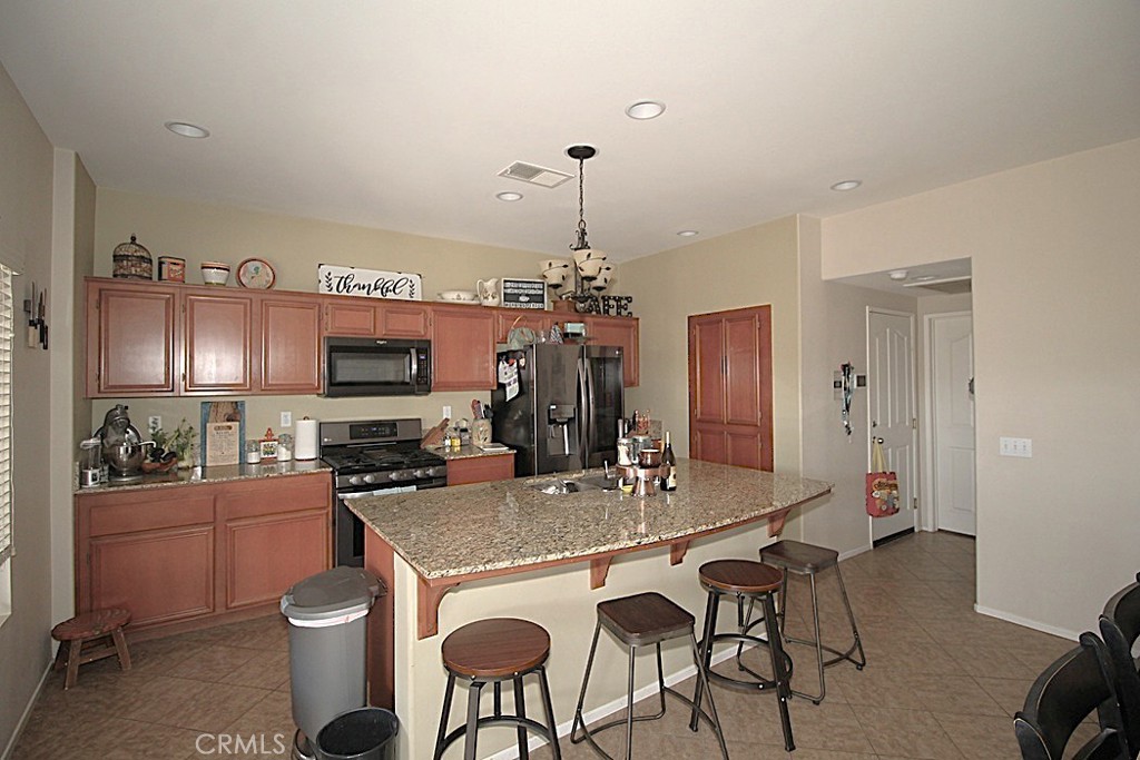 924 Condor Street Barstow, CA 92311 - Photo 13 of 52 a kitchen with a dining table chairs stainless steel appliances and cabinets