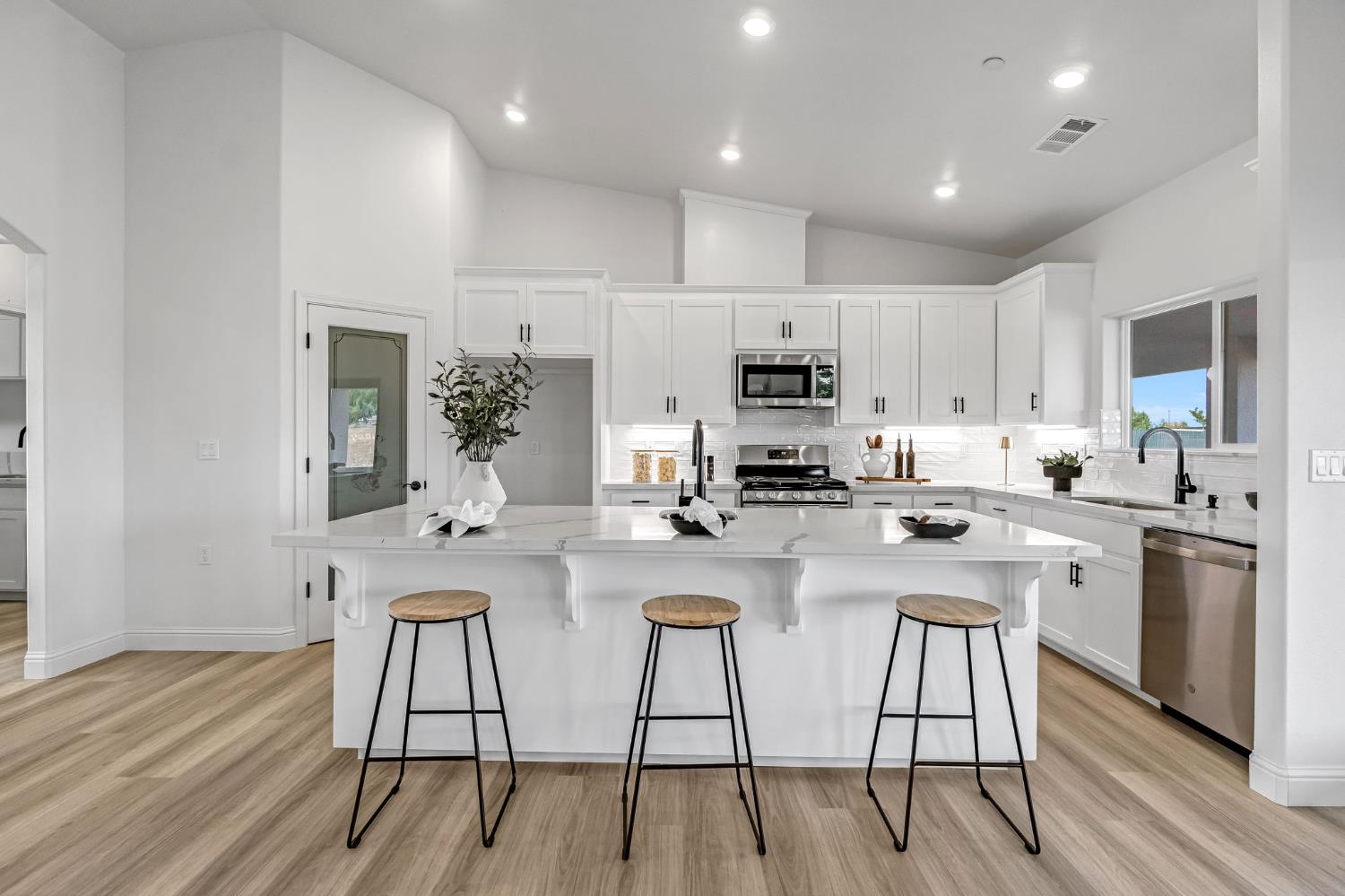 21035 Forest Glen Road Madera, CA 93638 - Photo 12 of 38 a kitchen with stainless steel appliances a table chairs refrigerator and cabinets