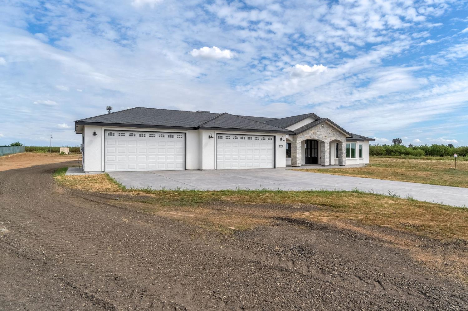 21035 Forest Glen Road Madera, CA 93638 - Photo 2 of 38 a front view of a house with a yard and garage