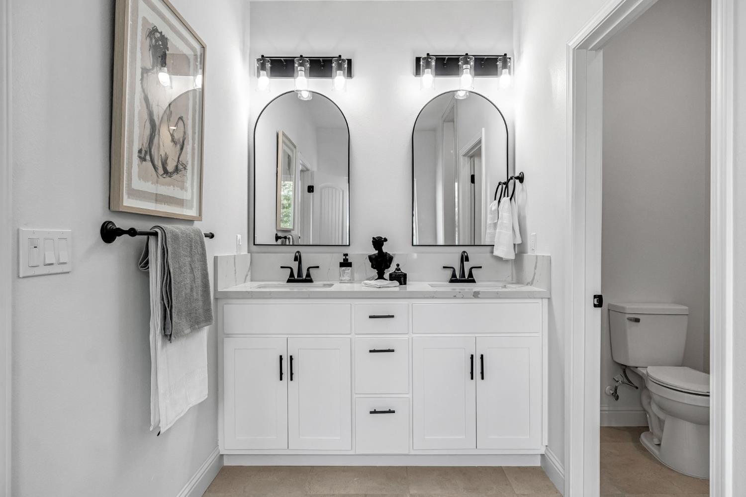 21035 Forest Glen Road Madera, CA 93638 - Photo 24 of 38 a bathroom with double vanity sinks and a toilet