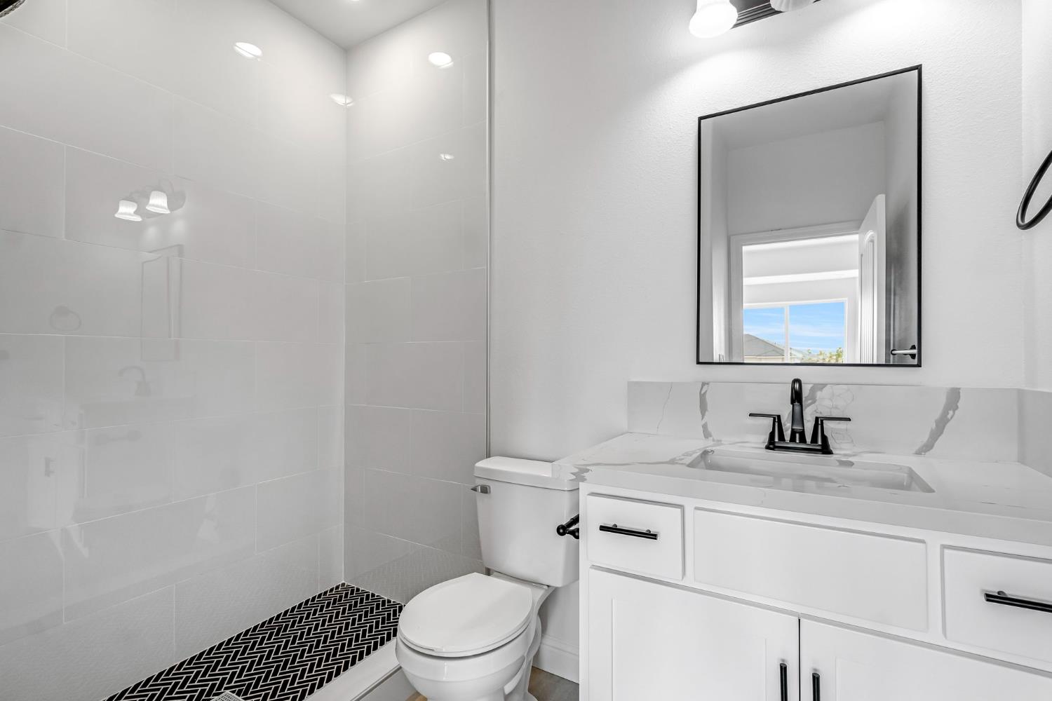 21035 Forest Glen Road Madera, CA 93638 - Photo 33 of 38 a bathroom with a toilet a sink and mirror