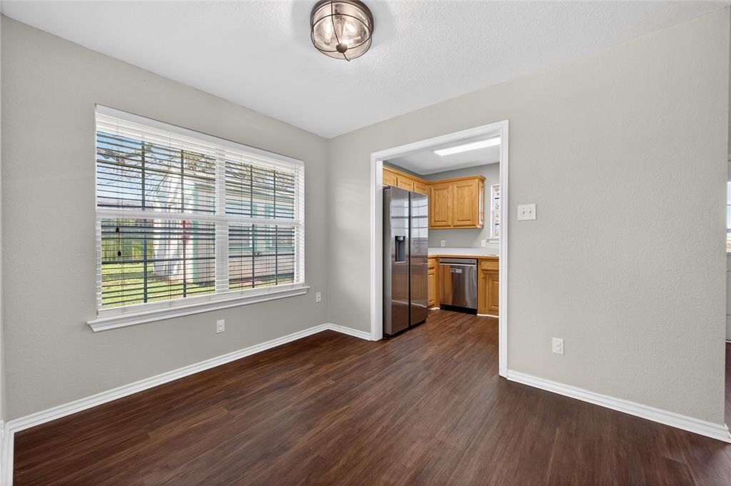 420 Robert Drive Springtown, TX 76082 - Photo 10 of 38 an empty room with wooden floor cabinet and windows