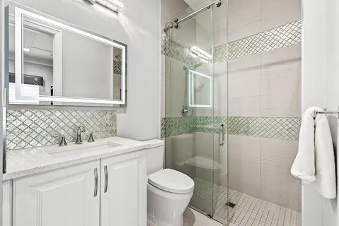 a bathroom with a shower sink and mirror