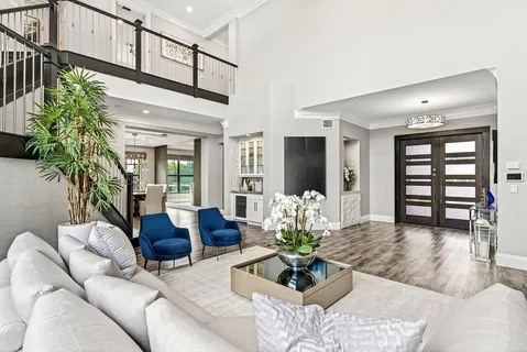 a living room with furniture flat screen tv and a large window