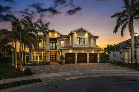 a view of swimming pool that has lawn chairs potted plants and palm trees