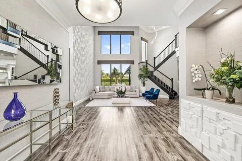 a living room with furniture and a large window with kitchen view