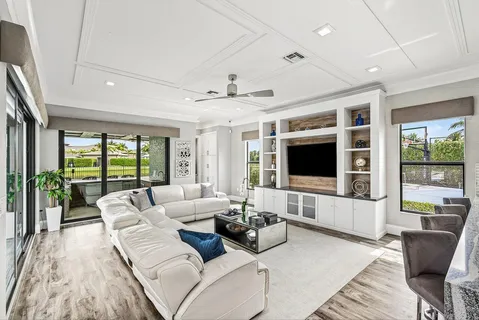 a living room with furniture kitchen view and a large window
