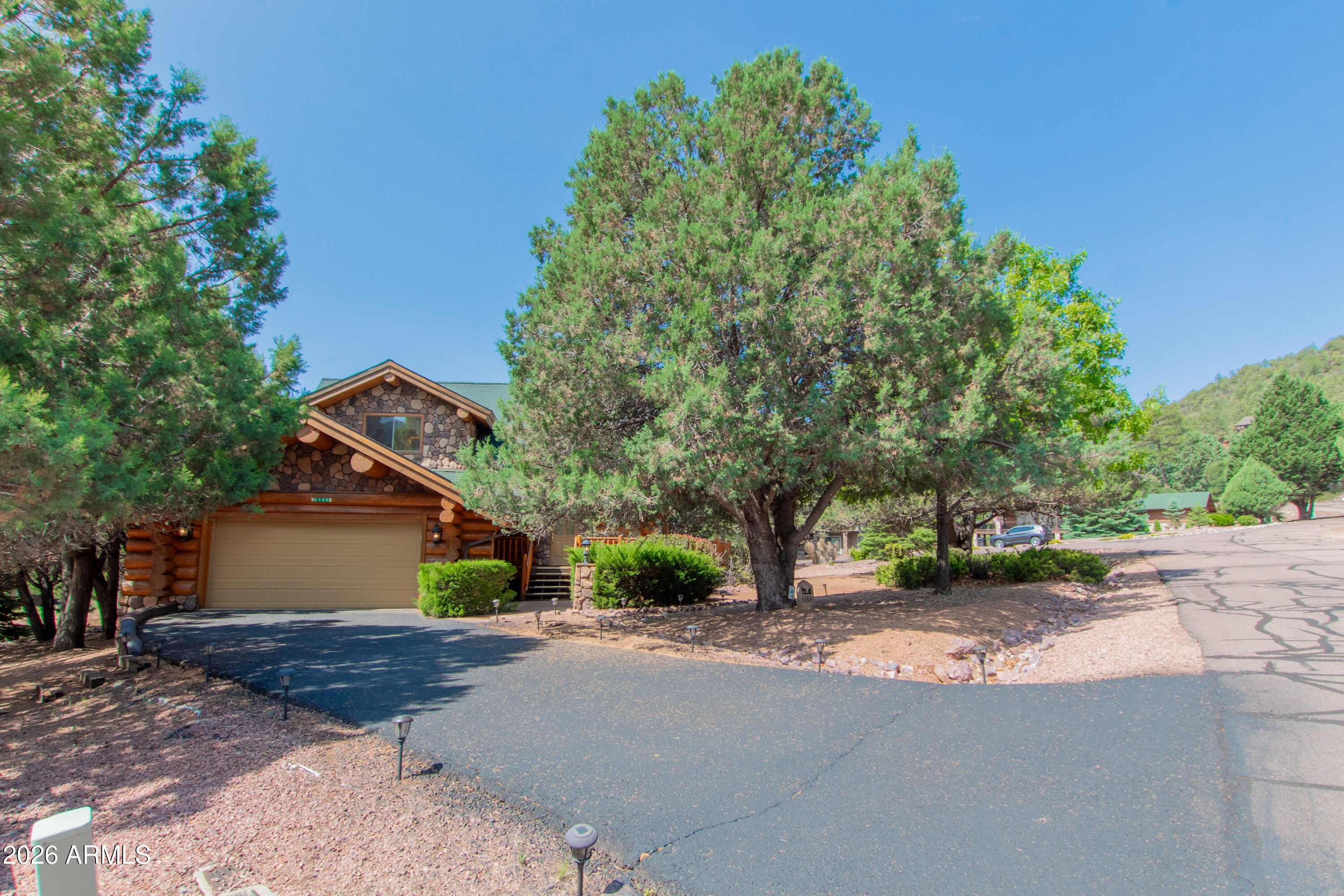 6168 Hidden Pines Loop Pine, AZ 85544 - Photo 22 of 25 a front view of a house with a yard and garage