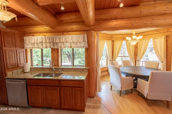 a dining room with granite countertop a sink and dishwasher with wooden floor