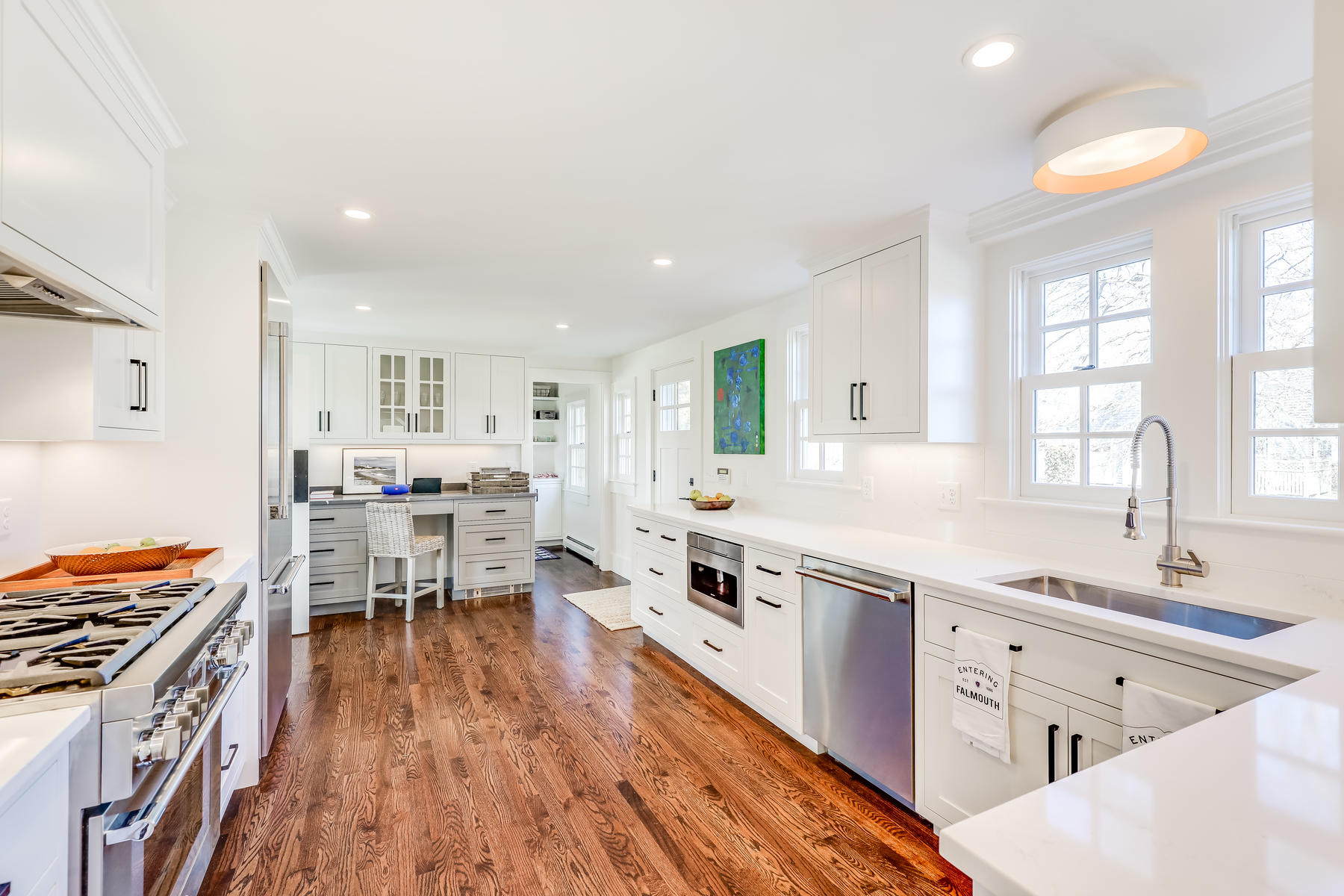 67 Quonset Road Falmouth, MA 02540 - Photo 17 of 55 a kitchen with stainless steel appliances a stove a sink dishwasher and a dining table with wooden floor