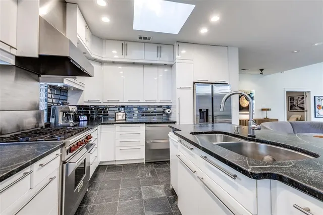 a kitchen with stainless steel appliances granite countertop a sink stove and cabinets