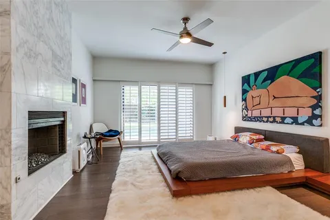 a bedroom with a bed a fireplace and a large window