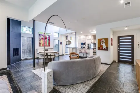 a living room with furniture a dining table and a large window