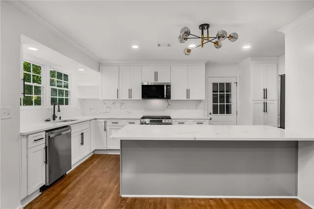 a large kitchen with granite countertop a stove and a sink