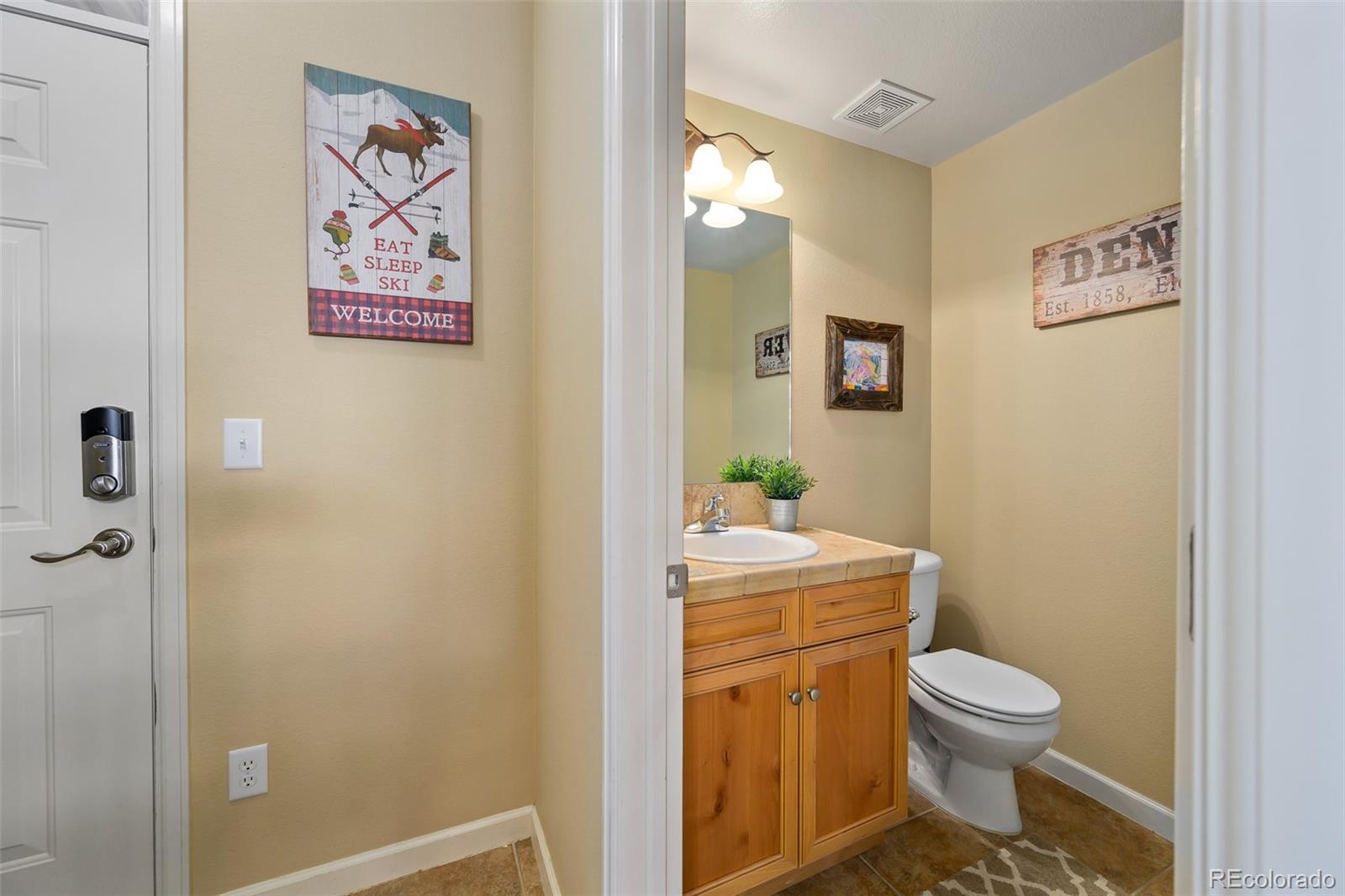 180 County Road, Unit 1 Fraser, CO 80442 - Photo 11 of 37 a bathroom with a granite countertop toilet a sink and a mirror