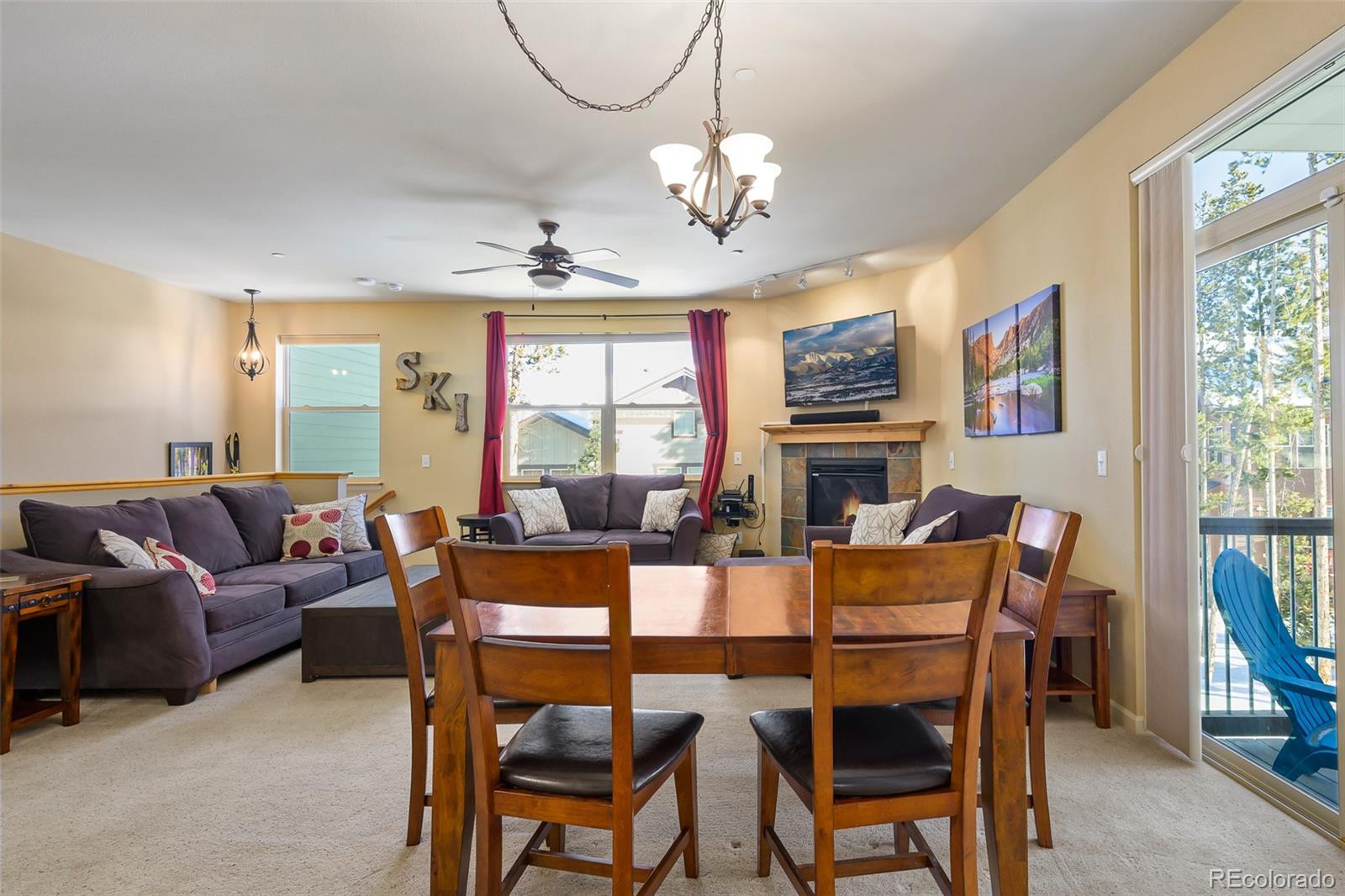 180 County Road, Unit 1 Fraser, CO 80442 - Photo 14 of 37 a dining room with wooden floor a chandelier a wooden table and chairs
