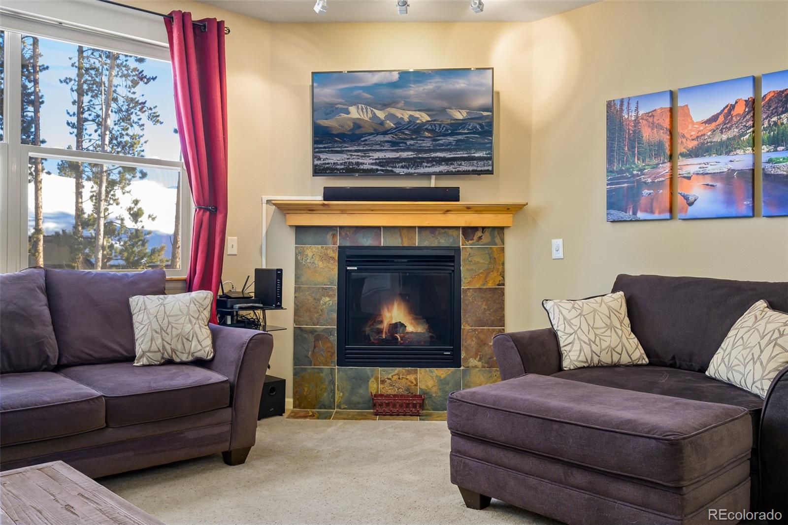180 County Road, Unit 1 Fraser, CO 80442 - Photo 18 of 37 a living room with furniture a fireplace and a large window
