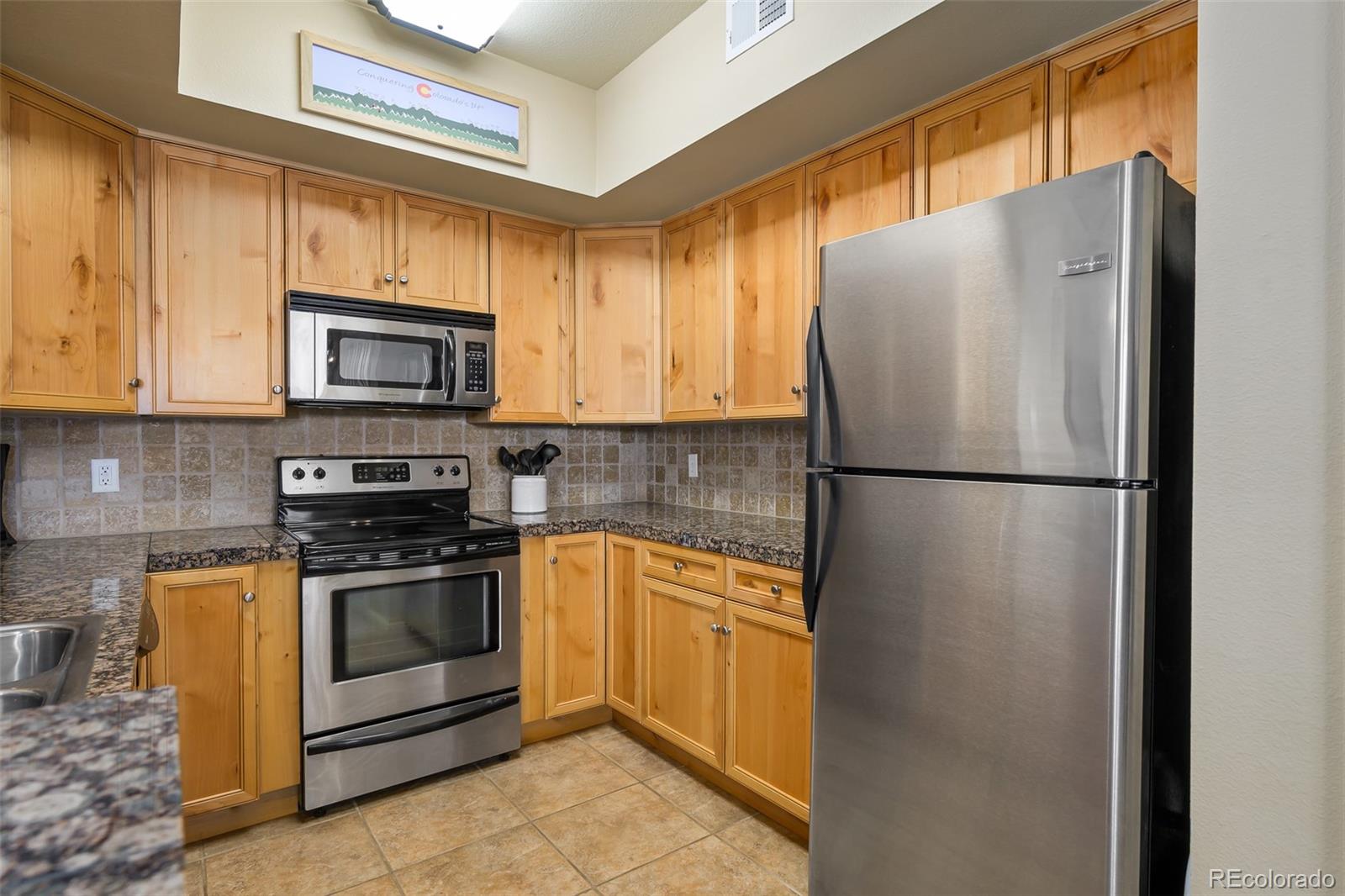 180 County Road, Unit 1 Fraser, CO 80442 - Photo 24 of 37 a kitchen with stainless steel appliances granite countertop a refrigerator a stove a sink and a window