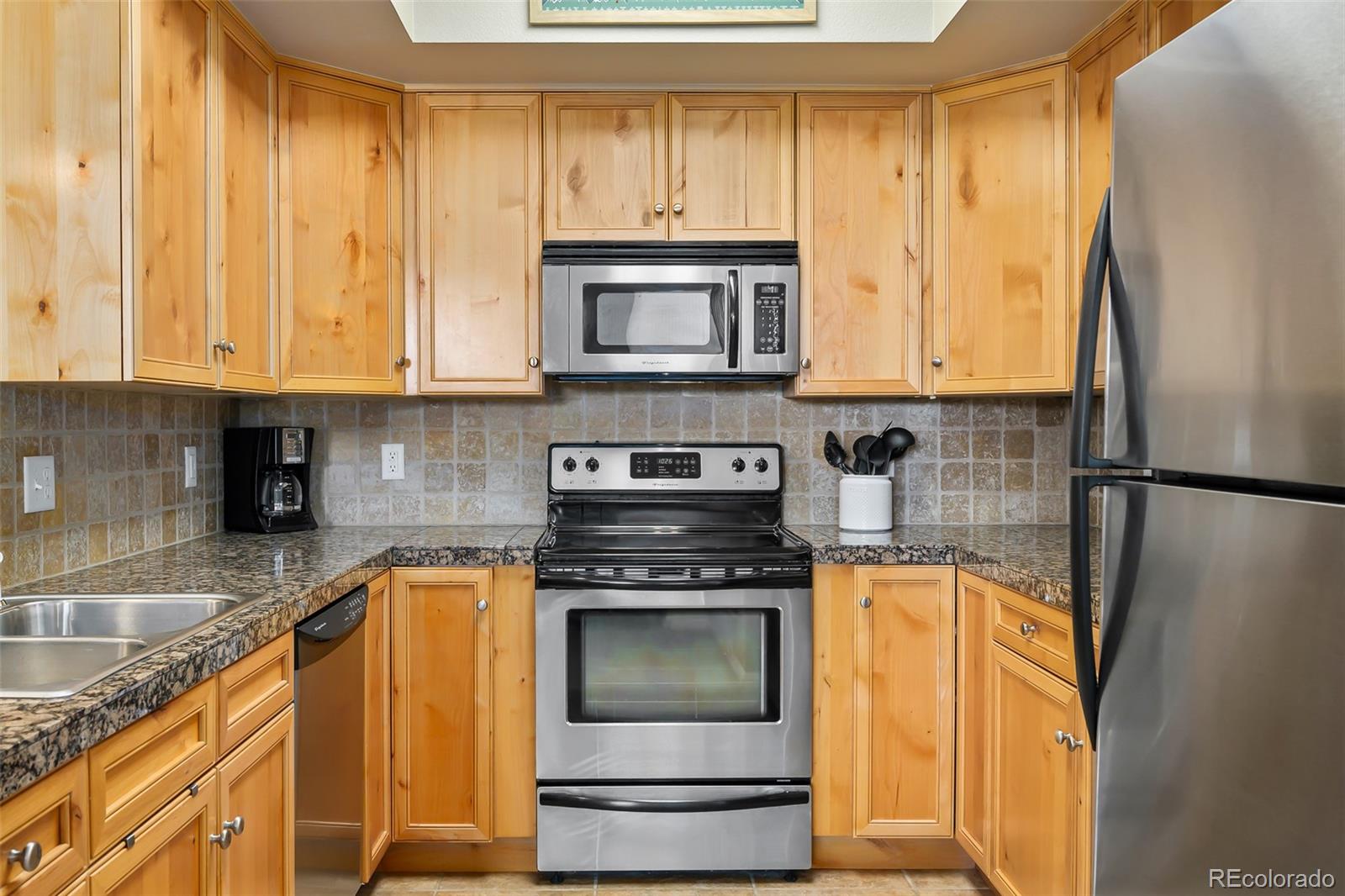 180 County Road, Unit 1 Fraser, CO 80442 - Photo 26 of 37 a kitchen with stainless steel appliances granite countertop a stove a sink and a microwave