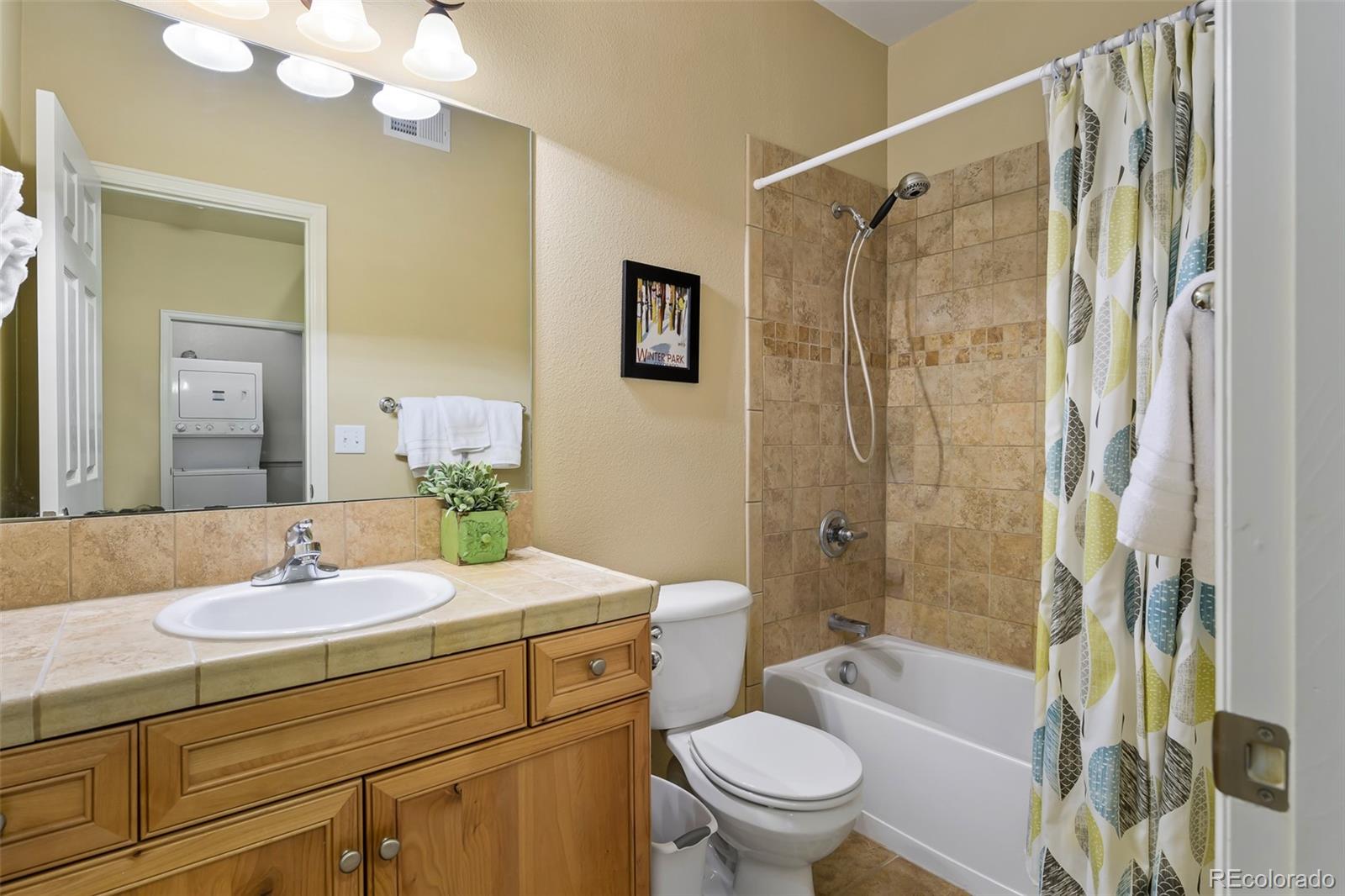 180 County Road, Unit 1 Fraser, CO 80442 - Photo 36 of 37 a bathroom with a sink a toilet a mirror a bathtub and shower