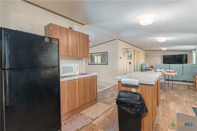 a kitchen with stainless steel appliances granite countertop a refrigerator and a stove