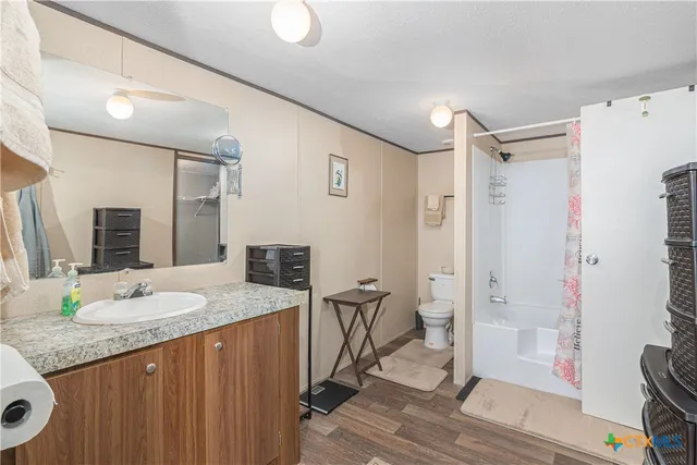 a bathroom with a granite countertop sink toilet and shower