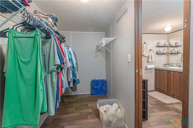 a view of walk in closet with clothes and shoes