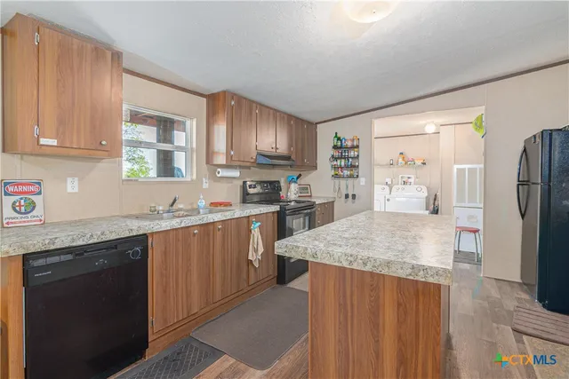 a kitchen with stainless steel appliances granite countertop a sink refrigerator and microwave