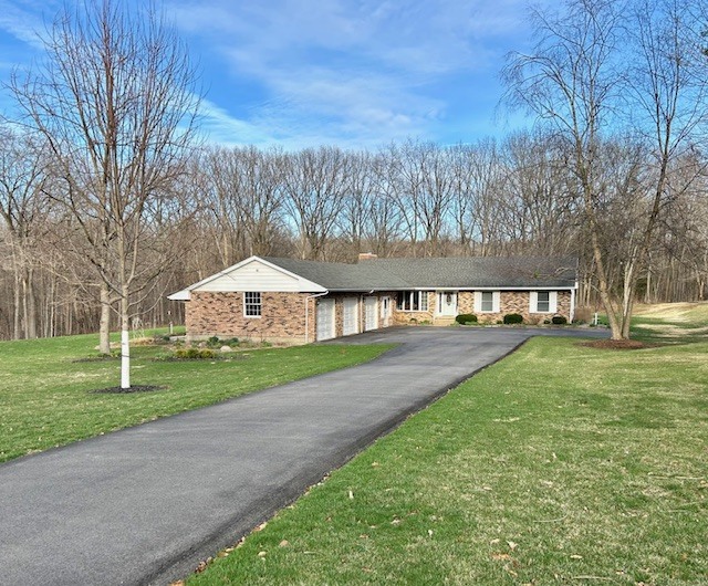 a view of a house with a yard and sitting area