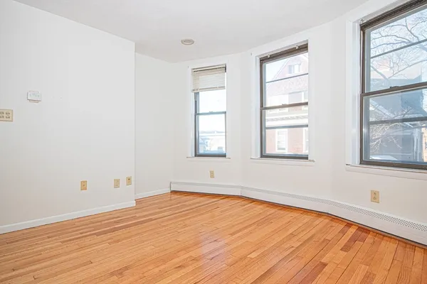 an empty room with a window and wooden floor