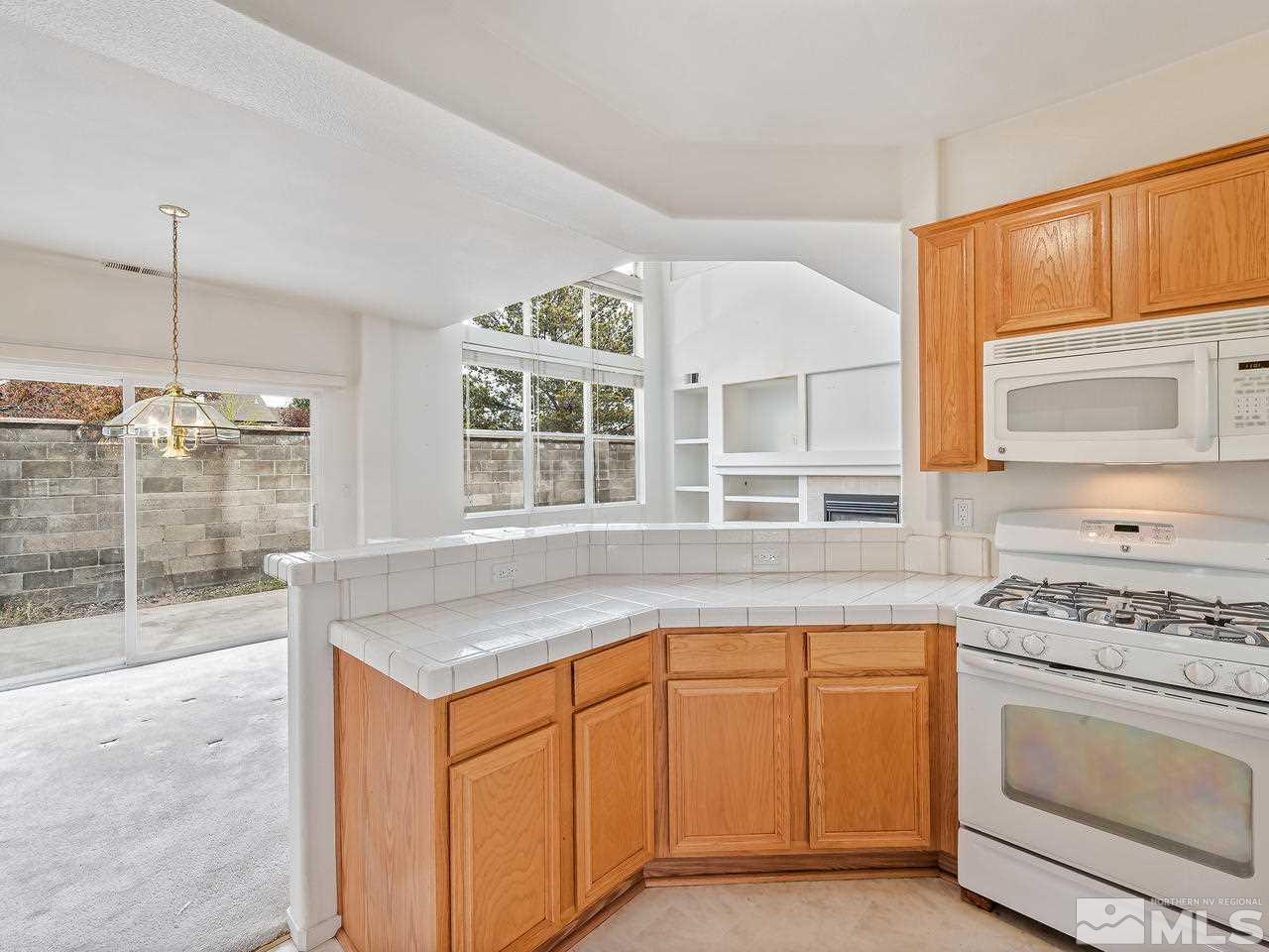 1287 Tule Drive Reno, NV 89521 - Photo 14 of 32 a kitchen with granite countertop a stove and a sink